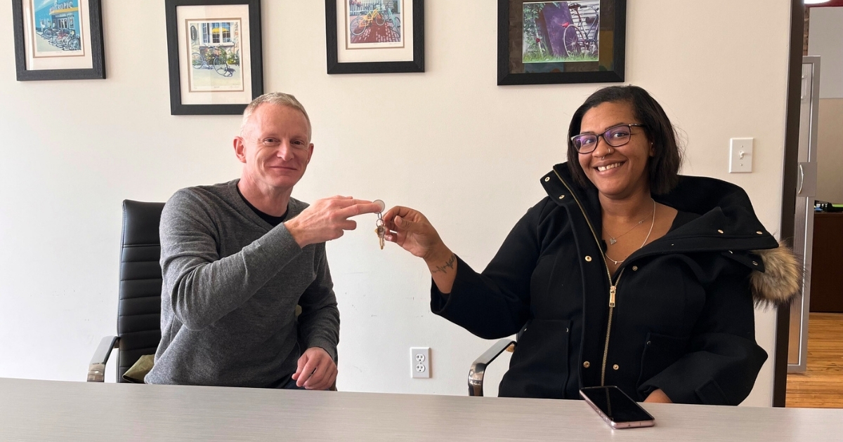 Brent Taylor, Habitat Capital Region President & CEO, hands Brittni the keys to her "manifesting home".