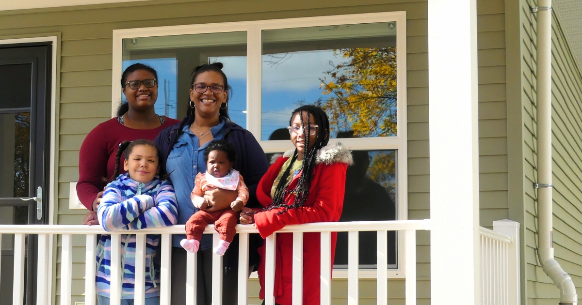 Brittni and her four kids stand for a photo in front of their new home.