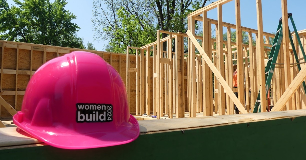 A pink Women Build hard hart sits in the window frame of Carly's home during the construction.