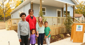 Carly's Home Base: Carly and her children pose for a photo in front of the new Habitat house.